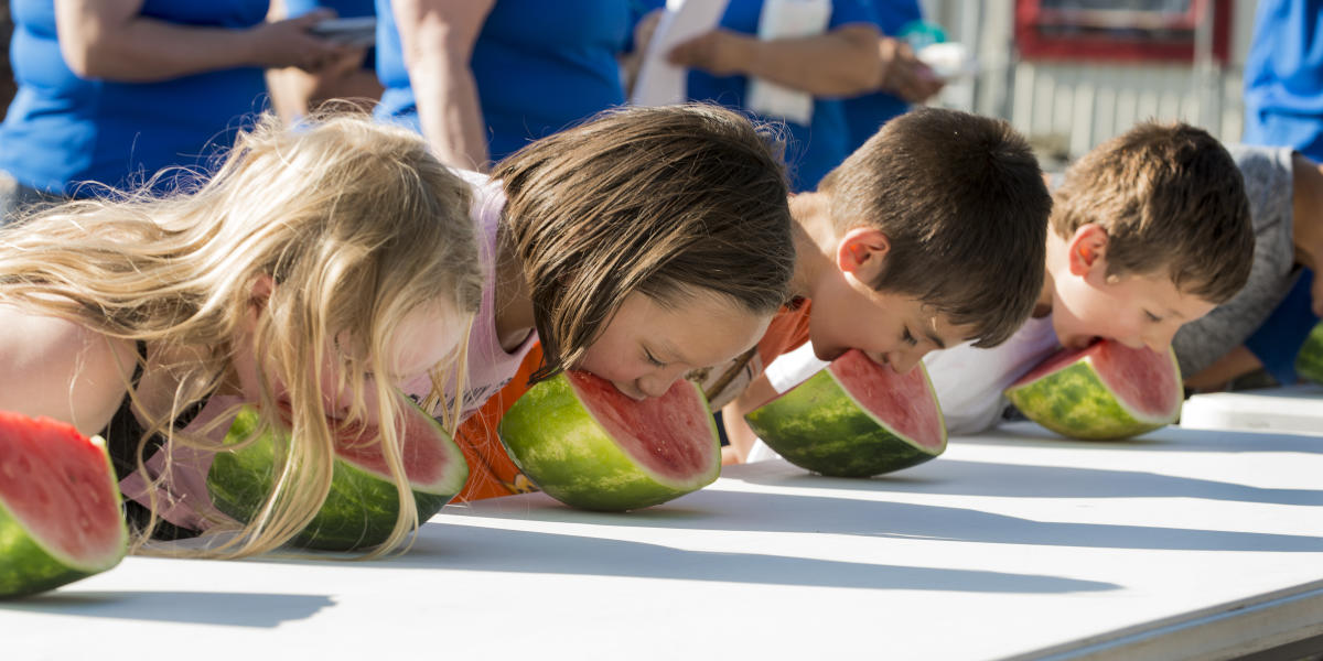 Children eating watermelon in an "Old Tyme Games" contest at the Golden Days Celebration.