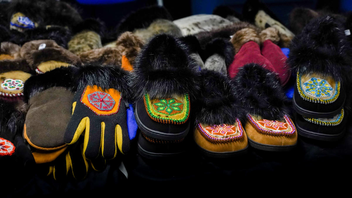 An assortment of shoes and gloves adorned with colorful beadwork and black fur.