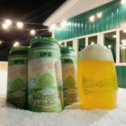 photo by Amy Geiger/Explore Fairbanks Four Aroma Dome Black Spruce IPA beers. Three beers are in cans, and one is in a glass.