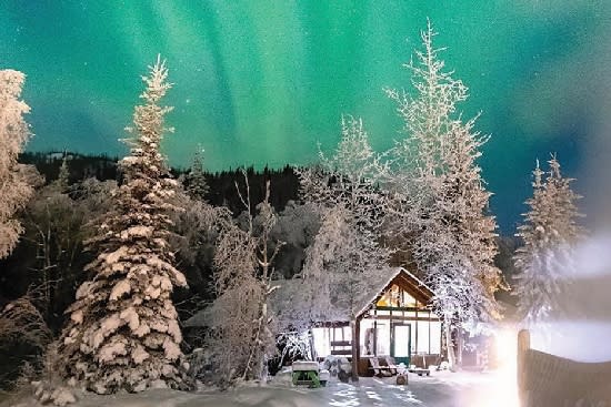 Vibrant green and teal aurora over Chena Hot Springs Cabin