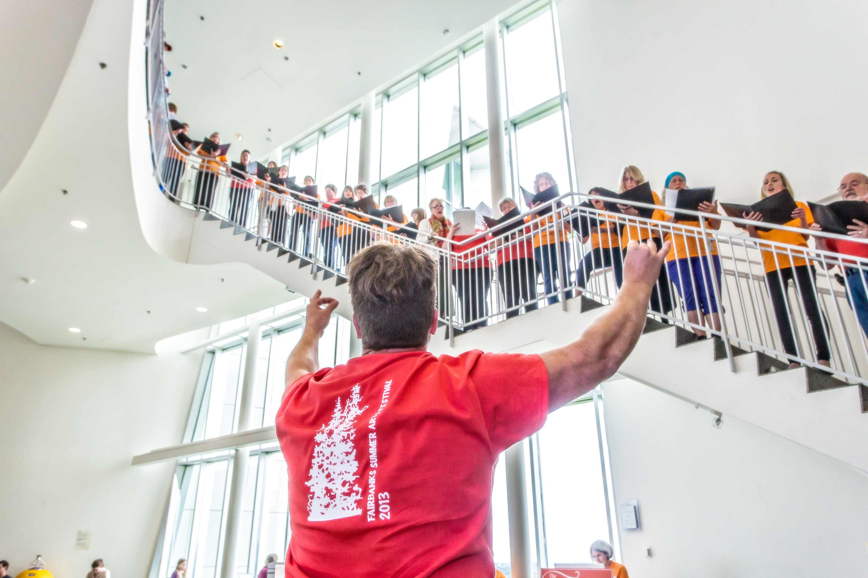 Person conducting choir at Museum of the North. Photo by Todd Paris.