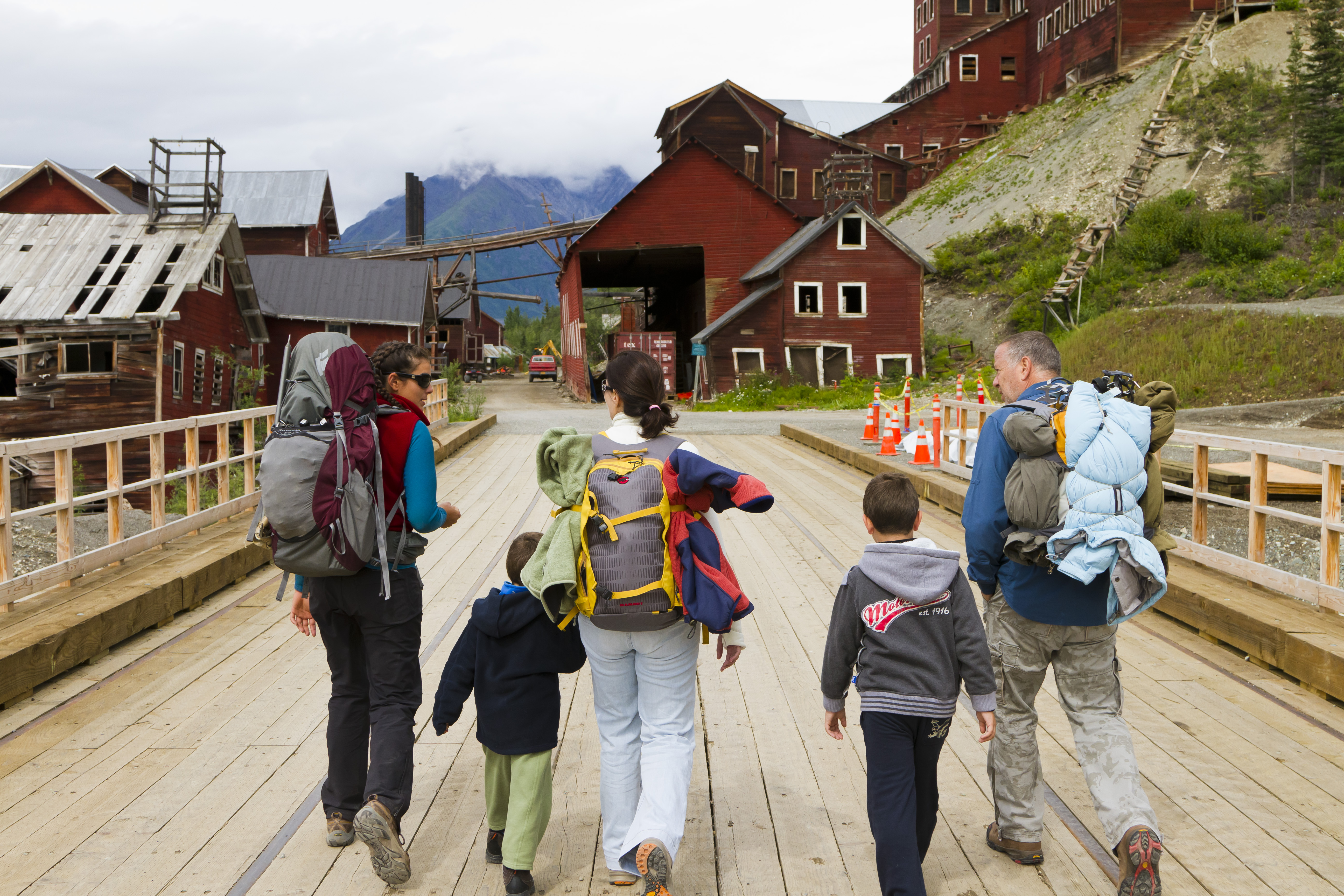 Five hikers walking across bridge at Kennicott Copper Mine