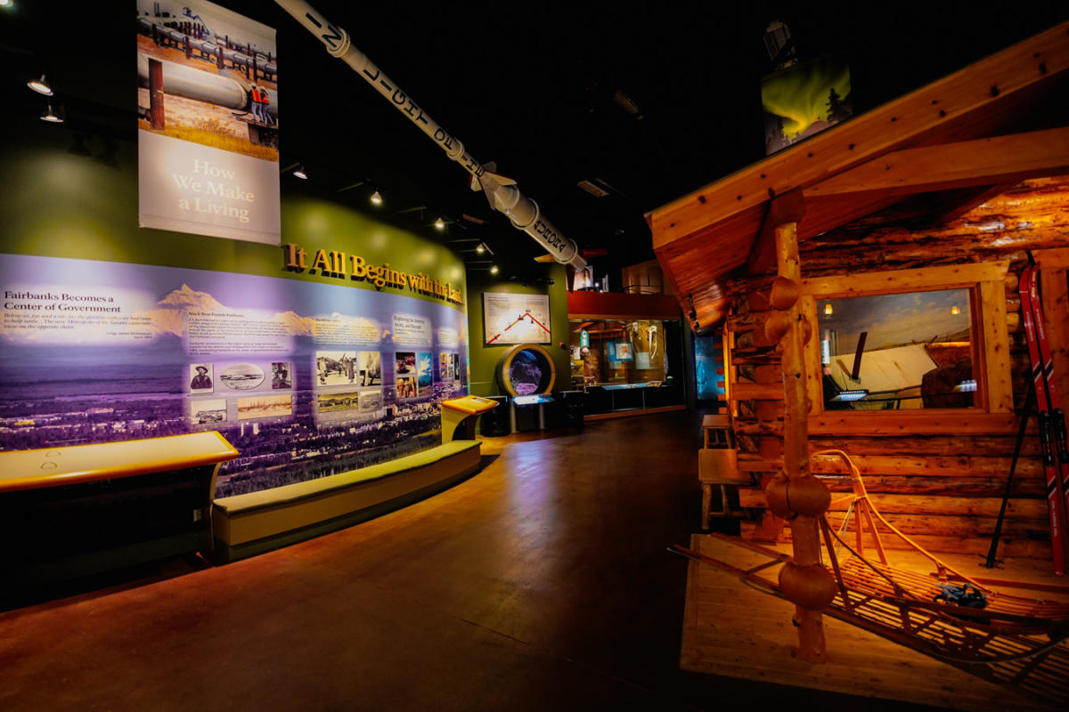 Indoor exhibit at the Morris Thompson Cultural and Visitors Center in Fairbanks, Alaska, featuring cultural scenes, wildlife dioramas, and seasonal landscapes