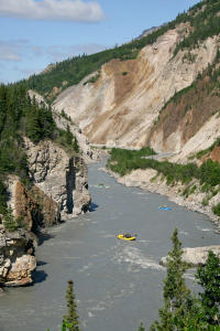 Whitewater rafting on a canyon river in Interior Alaska with rugged cliffs and scenic wilderness.