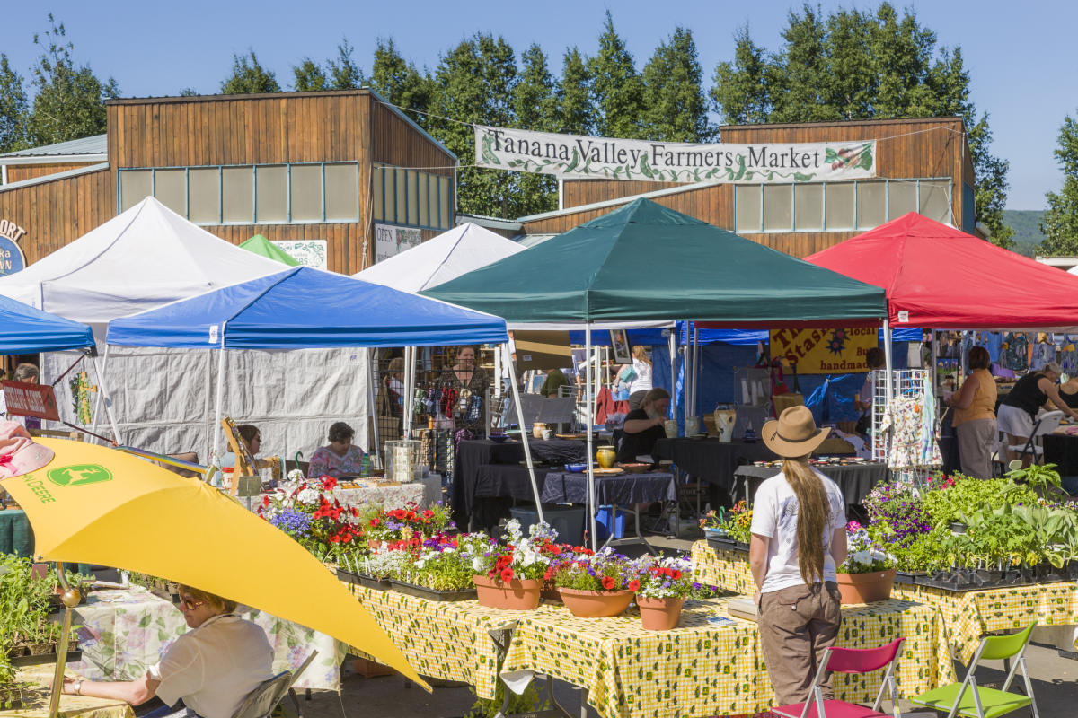 Vendors at the Tanana Valley Farmer's Market selling flowers and other locally made goods.