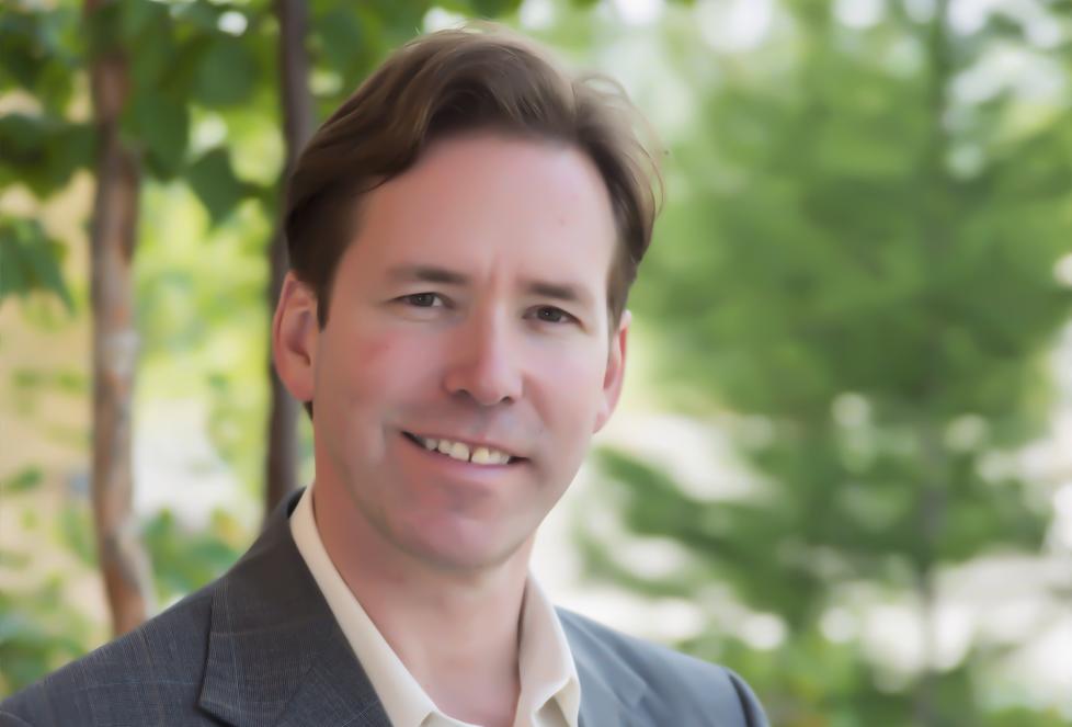 Portrait of man wearing suit with blurred trees in background